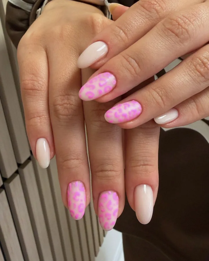 Milky almond nails with a pink leopard design on three nails