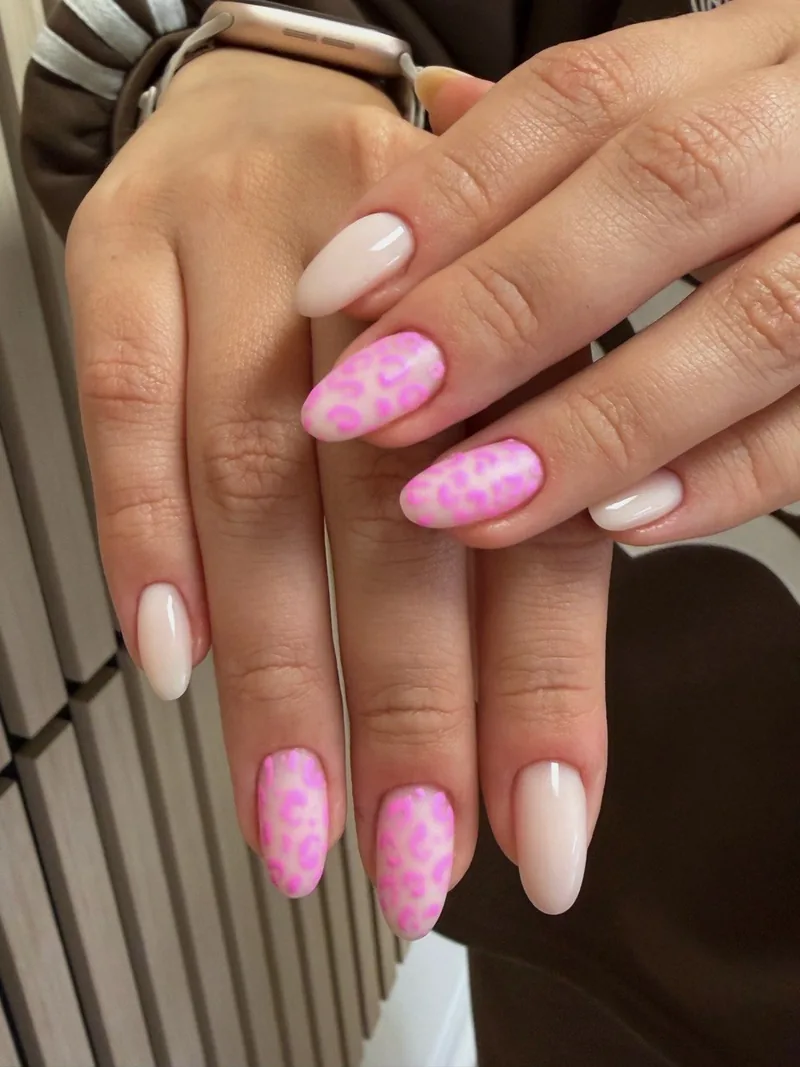 Milky almond nails with a pink leopard design on three nails